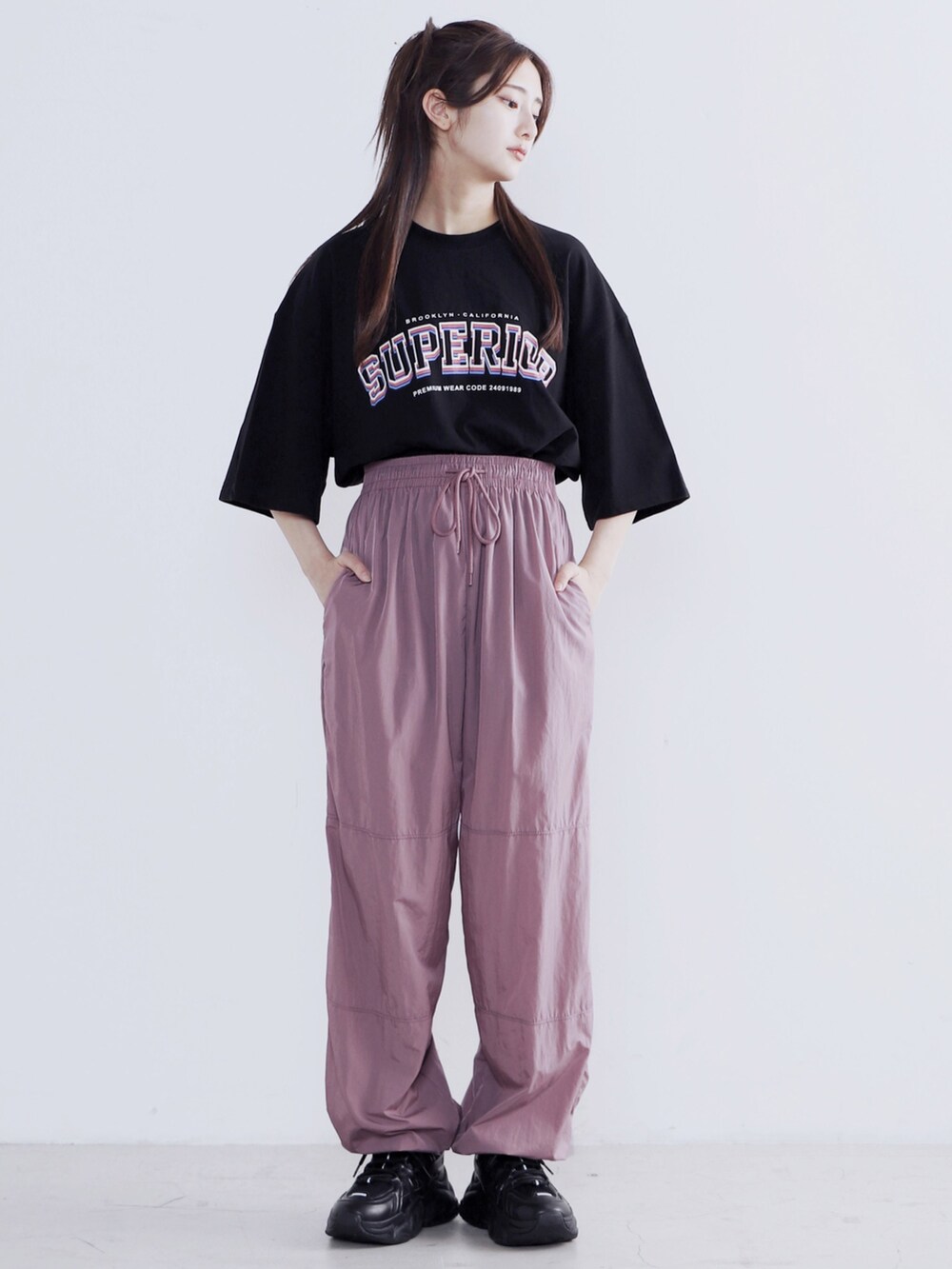 ピンク系のその他パンツ、ブラック系のスニーカー、ブラック系のTシャツ/カットソーを着用したレディースの夏コーディネートの2枚目の写真