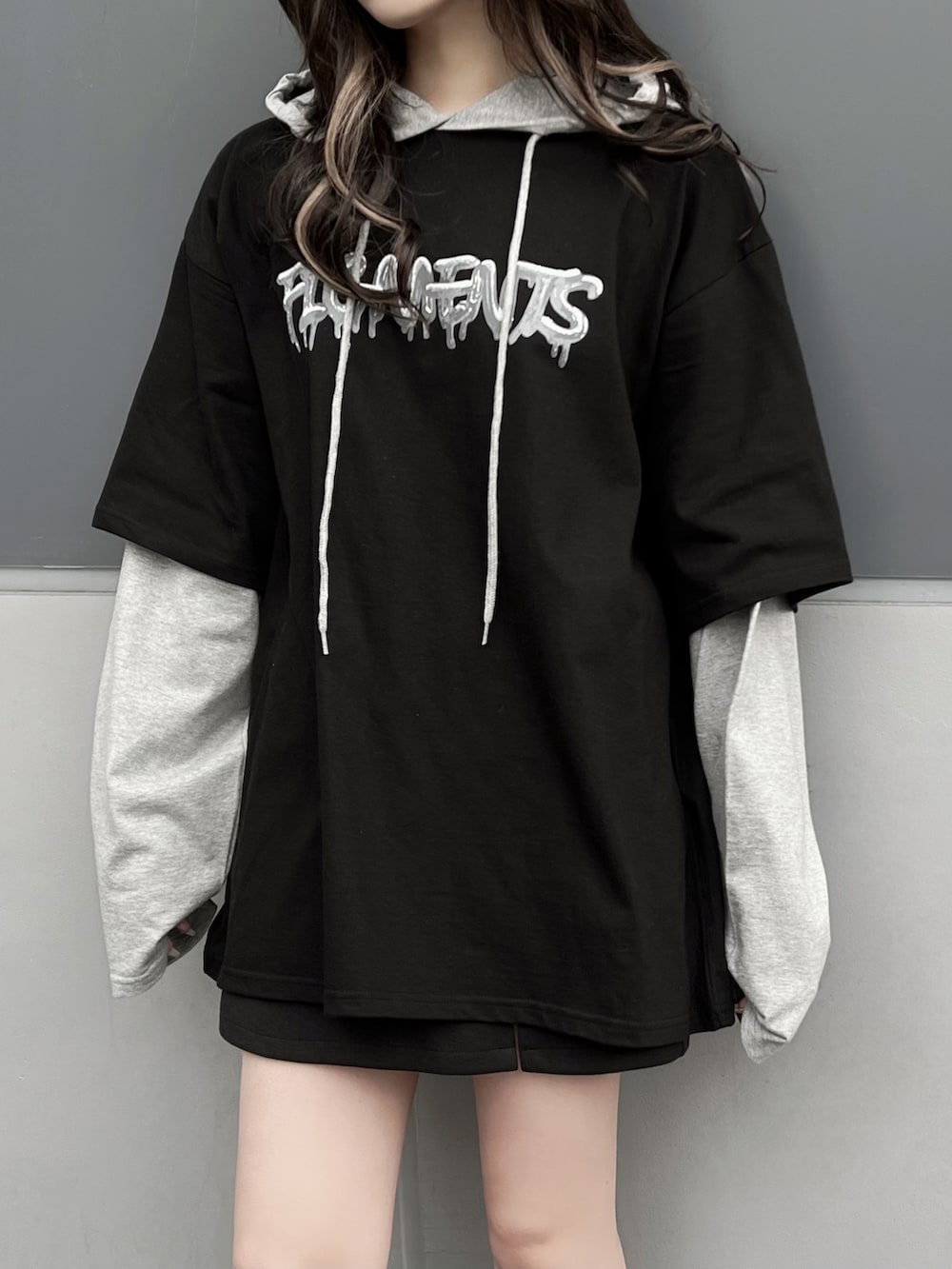 グレー系のTシャツ/カットソー、ブラック系のスカート、ブラック系のスニーカーを着用したレディースの春コーディネートの3枚目の写真