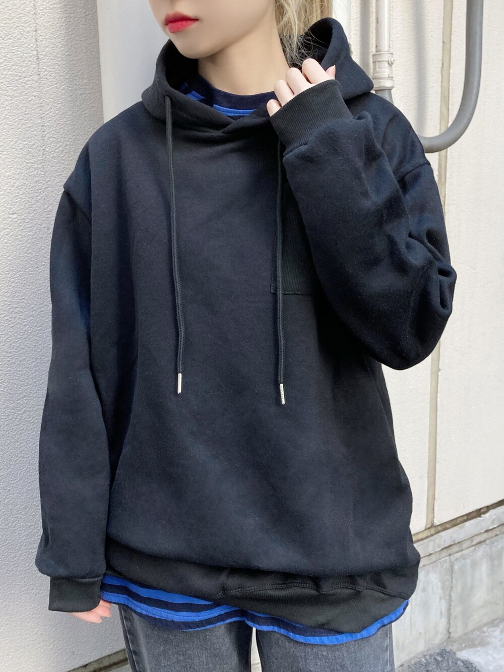 ブラック系のデニムパンツ、ブラック系のスニーカー、ブラック系のパーカーを着用したレディースの冬コーディネートの2枚目の写真