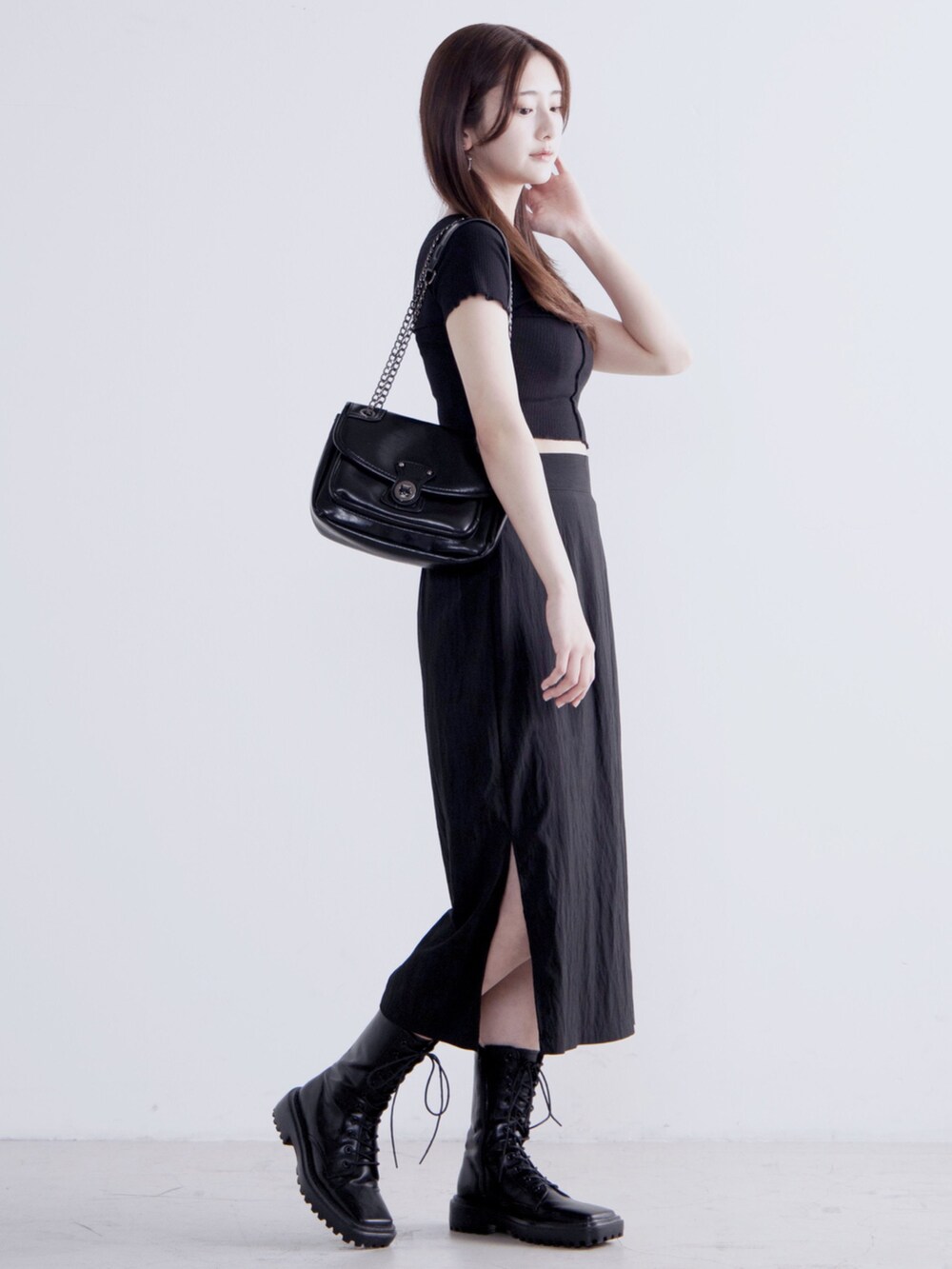 ブラック系のTシャツ/カットソー、ブラック系のスカート、ブラック系のショルダーバッグを着用したレディースの春コーディネートの2枚目の写真