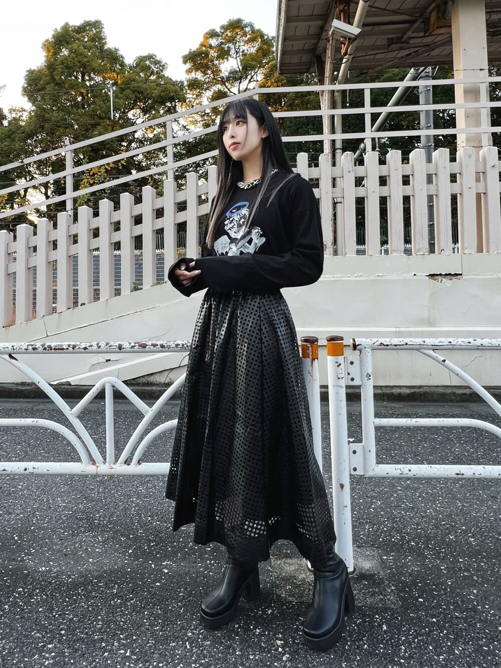 ブラック系のライダースジャケット、ブラック系のスカート、ブラック系のブーツを着用したレディースの冬コーディネートの3枚目の写真