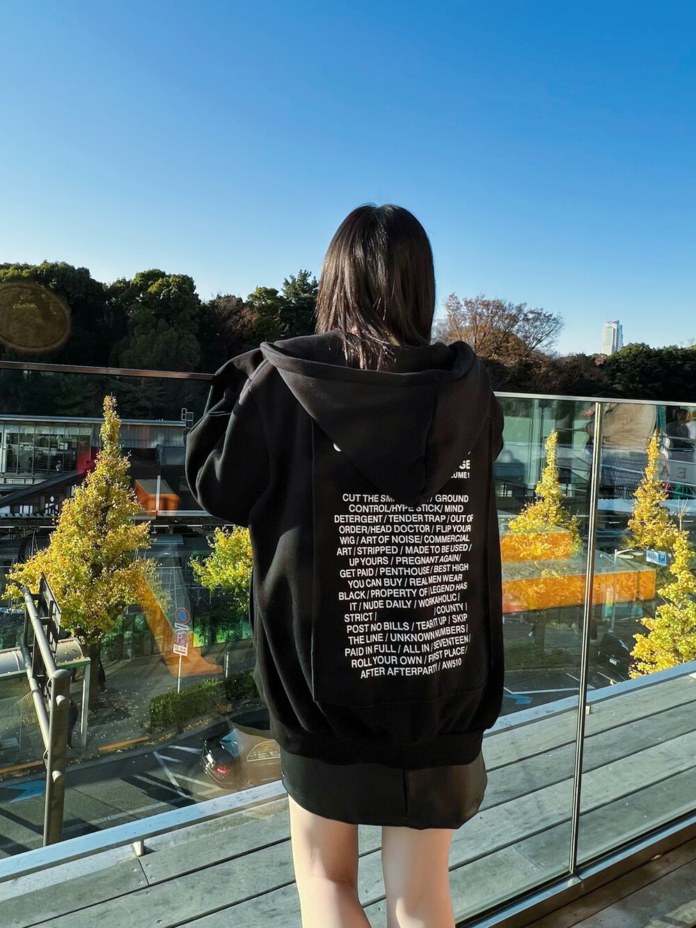 ブラック系のパーカー、ブラック系のスカート、ブラック系のブーツを着用したレディースの冬コーディネートの3枚目の写真