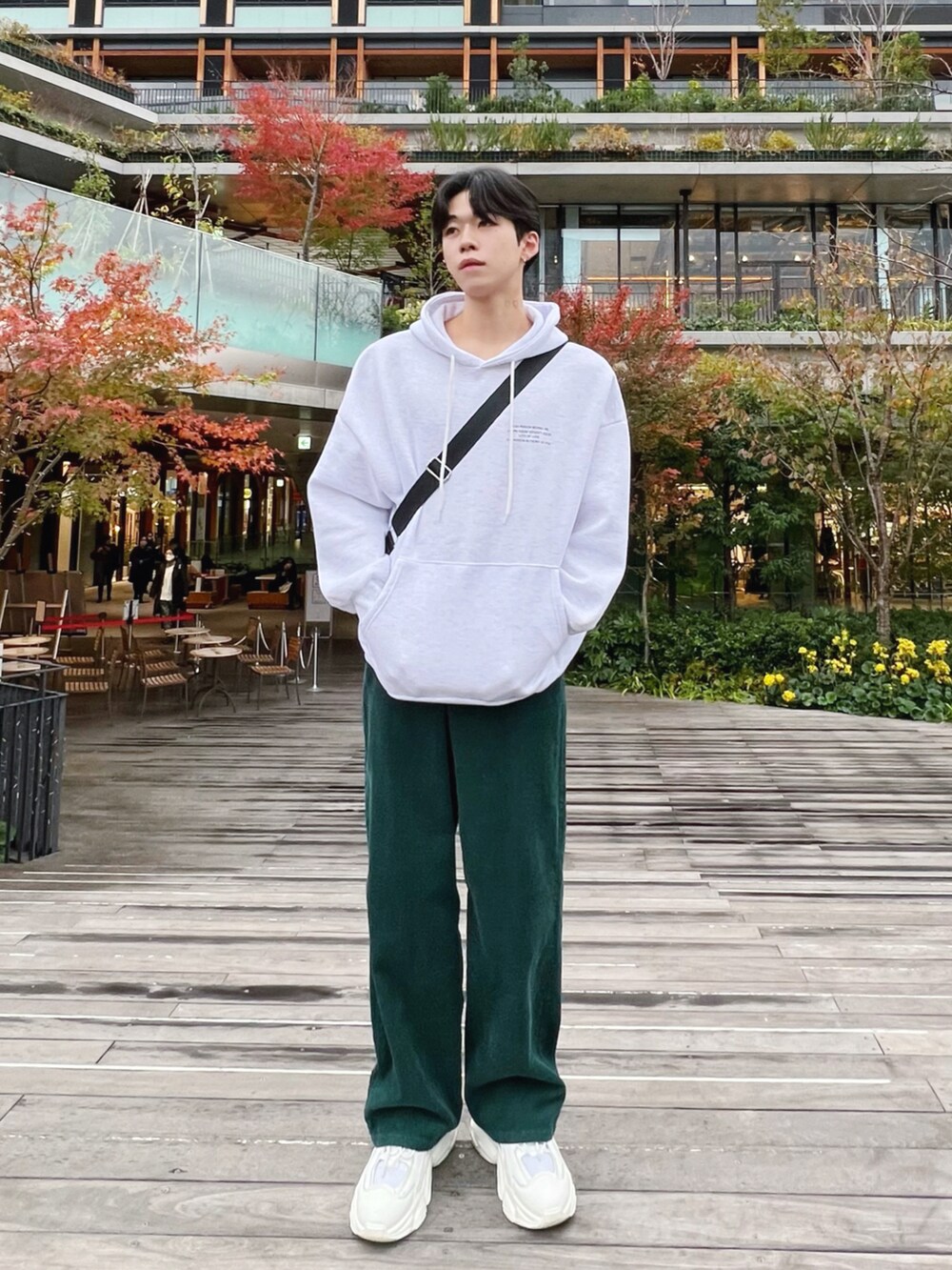 グレー系のパーカー、グリーン系のその他パンツ、ホワイト系のスニーカーを着用したメンズの冬コーディネートの2枚目の写真