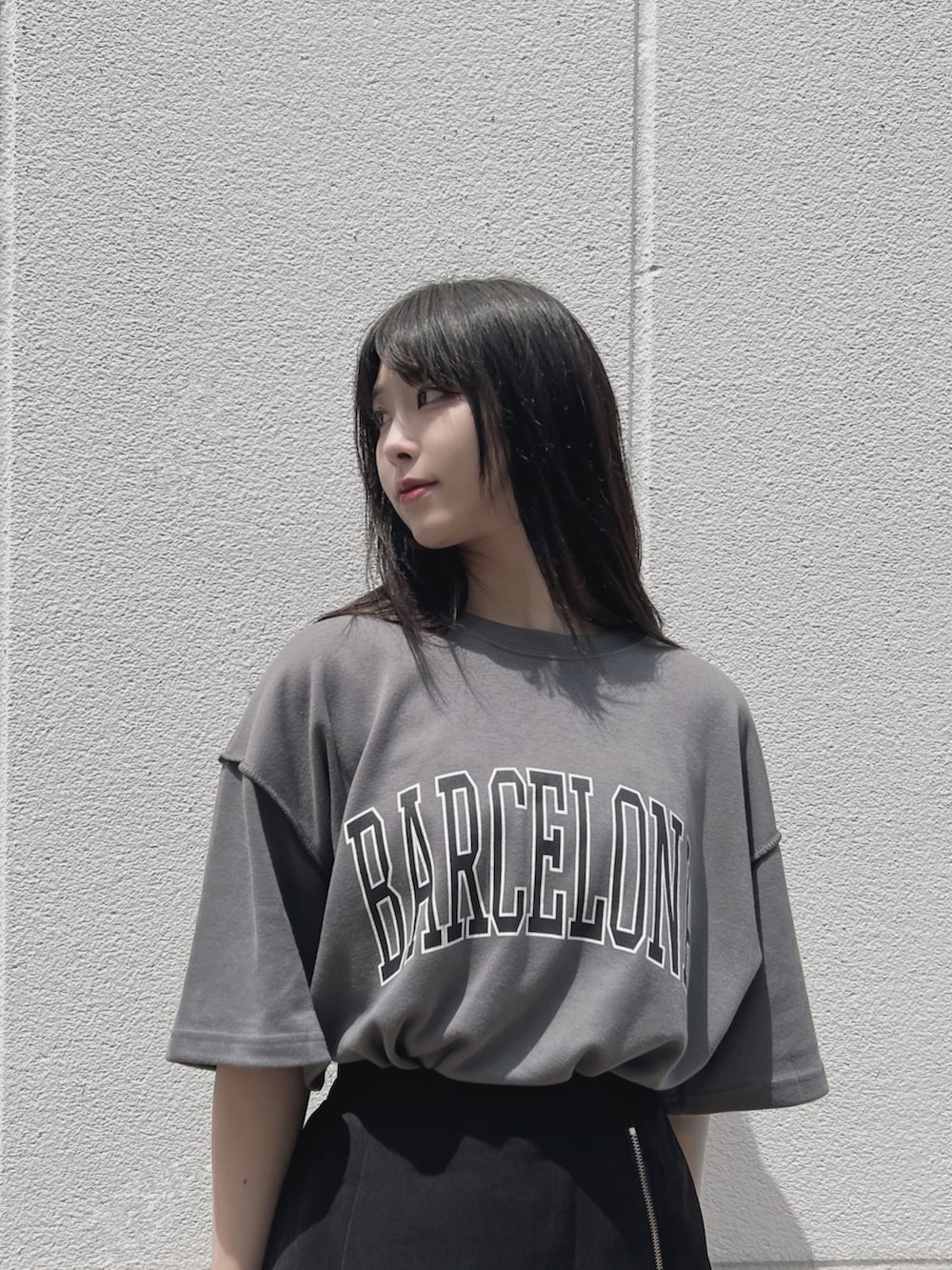 ブラック系のスニーカー、グレー系のTシャツ/カットソー、ブラック系のスカートを着用したレディースの夏コーディネートの2枚目の写真