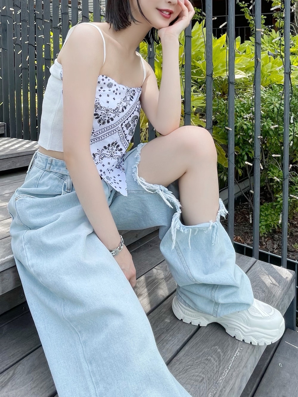 ブルー系のデニムパンツ、ホワイト系のスニーカー、ホワイト系のキャミソールを着用したレディースの夏コーディネートの3枚目の写真