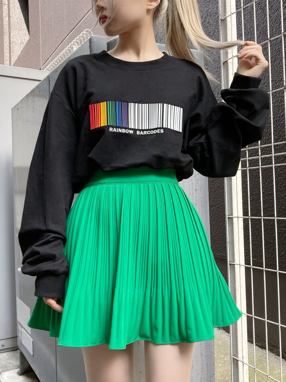 ブラック系のベスト、ブラック系のスウェット、グリーン系のスカートを着用したレディースの春コーディネートの3枚目の写真