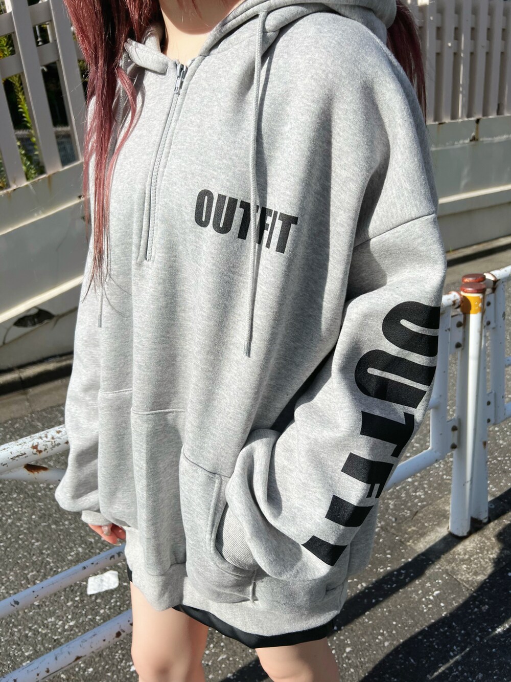 ブラック系のスニーカー、ブラック系のスカート、グレー系のパーカーを着用したレディースの冬コーディネートの4枚目の写真