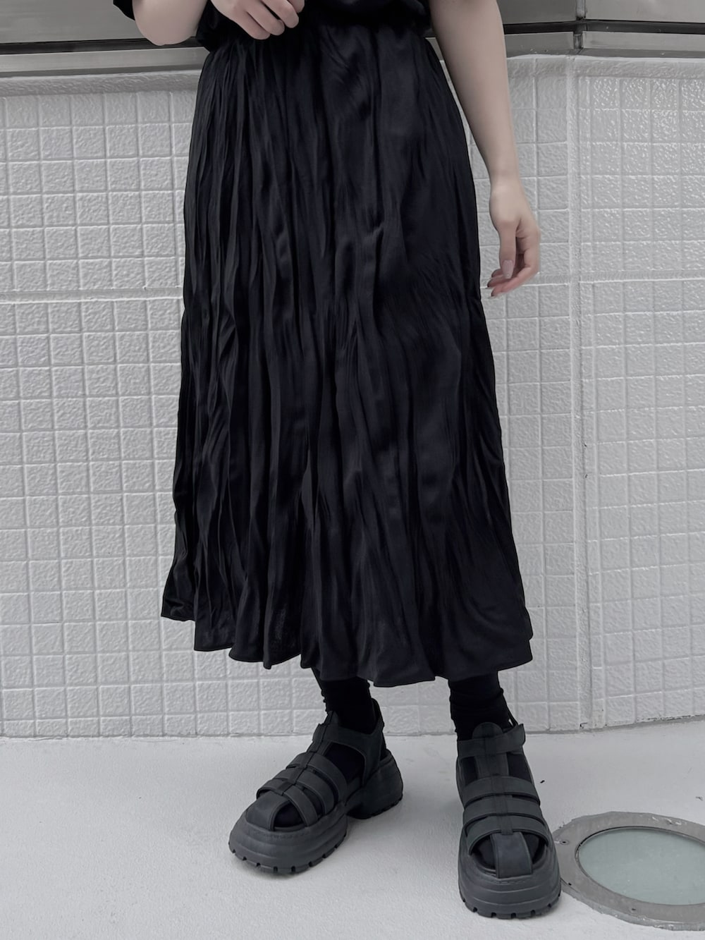 ブラック系のスカート、ブラック系のTシャツ/カットソー、ブラック系のサンダルを着用したレディースの夏コーディネートの3枚目の写真