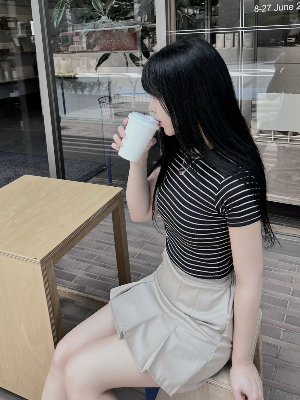 ベージュ系のスカート、ブラック系のTシャツ/カットソー、シルバー系のネックレスを着用したレディースの夏コーディネートの2枚目の写真