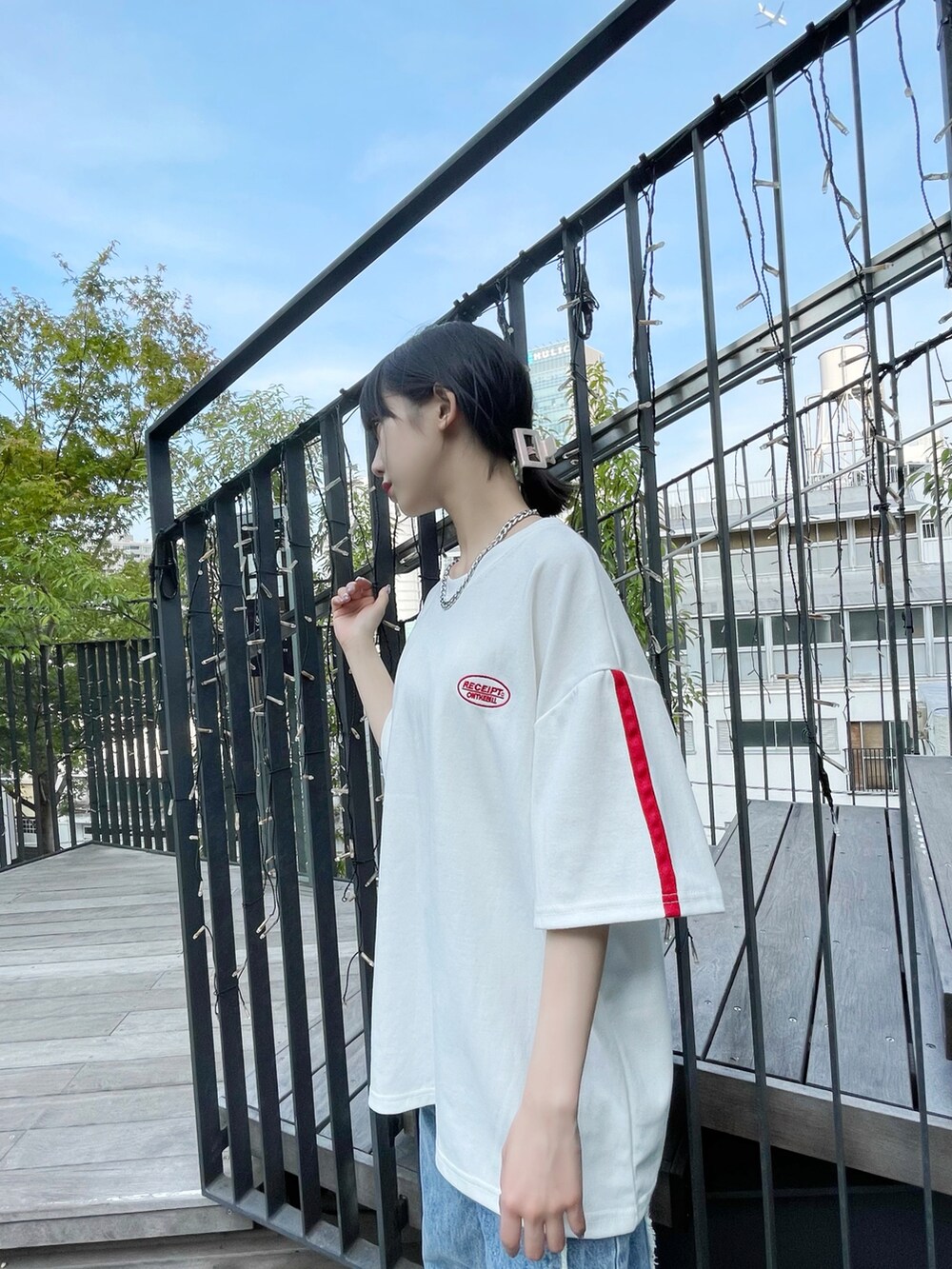 ホワイト系のスニーカー、ホワイト系のTシャツ/カットソー、ブルー系のデニムパンツを着用したレディースの夏コーディネートの2枚目の写真