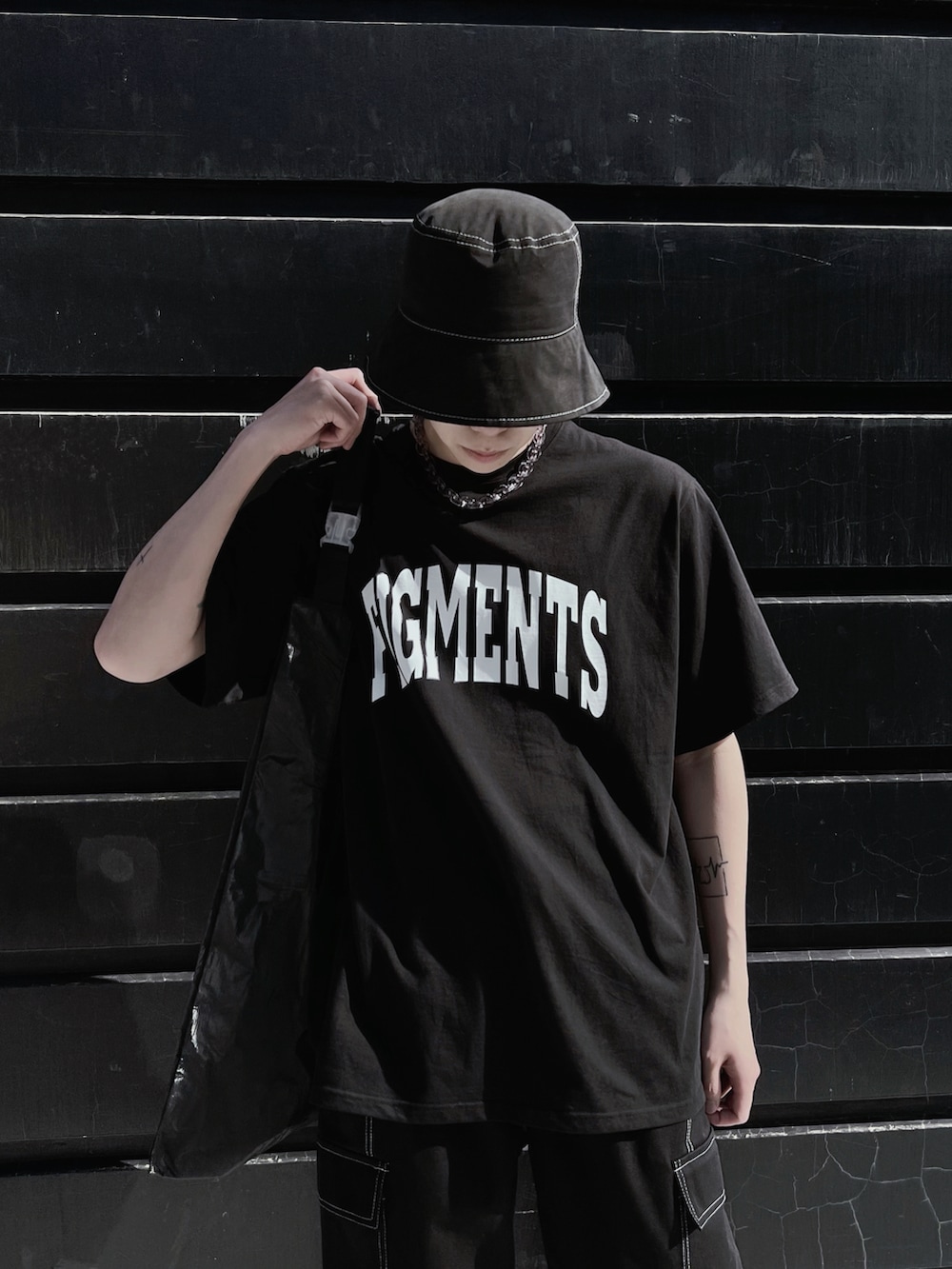 ブラック系のTシャツ/カットソー、ブラック系のトートバッグ、ホワイト系のスニーカーを着用したメンズの春コーディネートの2枚目の写真