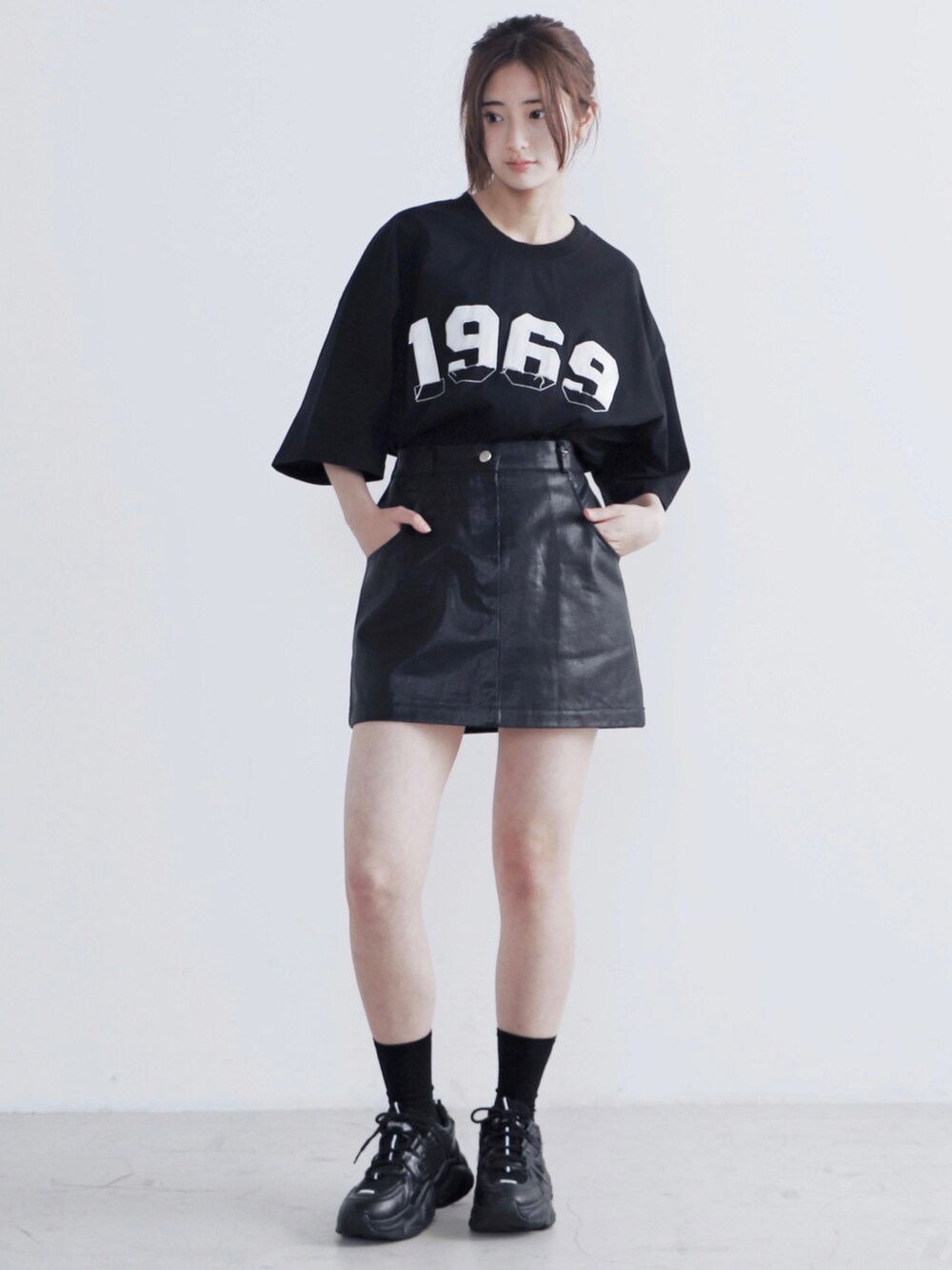 ブラック系のスカート、ブラック系のTシャツ/カットソー、ブラック系のスニーカーを着用したレディースの夏コーディネートの2枚目の写真