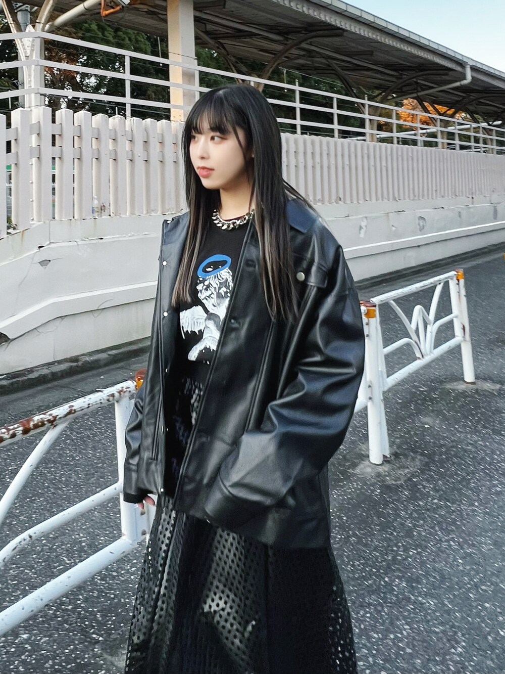 ブラック系のライダースジャケット、ブラック系のスカート、ブラック系のブーツを着用したレディースの冬コーディネートの2枚目の写真