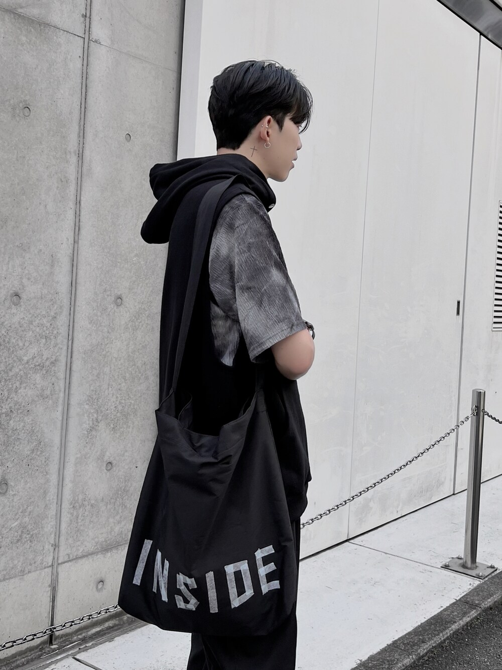 ブラック系のカーゴパンツ、ブラック系のショルダーバッグ、ブラック系のベストを着用したメンズの夏コーディネートの2枚目の写真