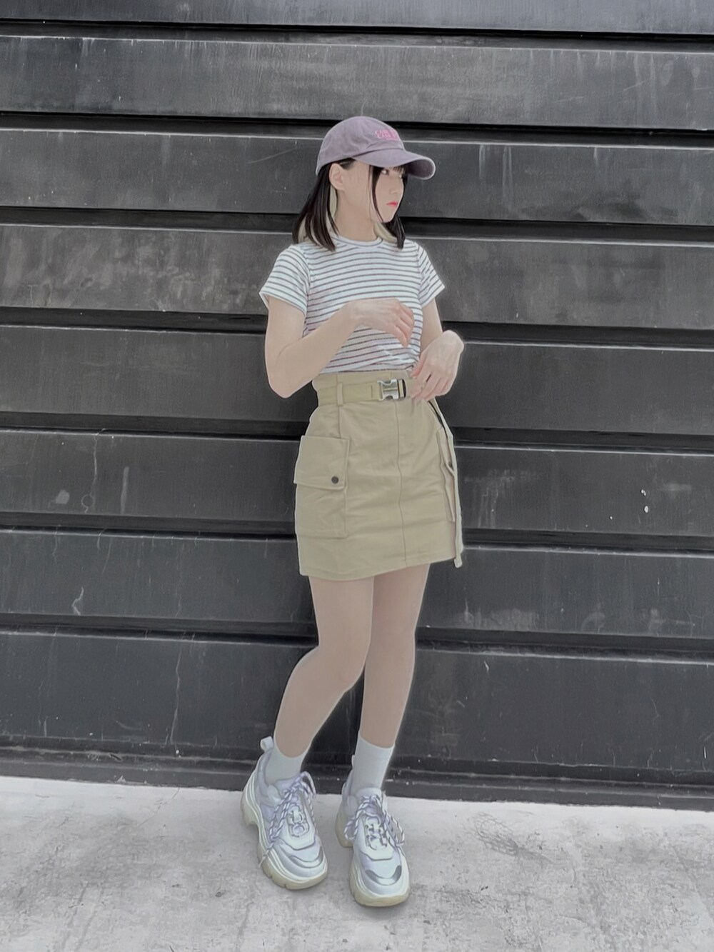 ホワイト系のTシャツ/カットソー、ベージュ系のスカート、グレー系のキャップを着用したレディースの夏コーディネートの2枚目の写真