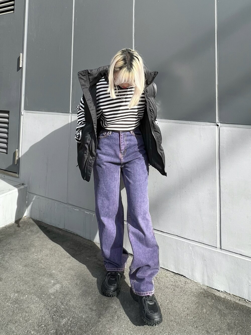 ホワイト系のTシャツ/カットソー、ブラック系のダウンベスト、ブラック系のスニーカーを着用したレディースの冬コーディネートの2枚目の写真