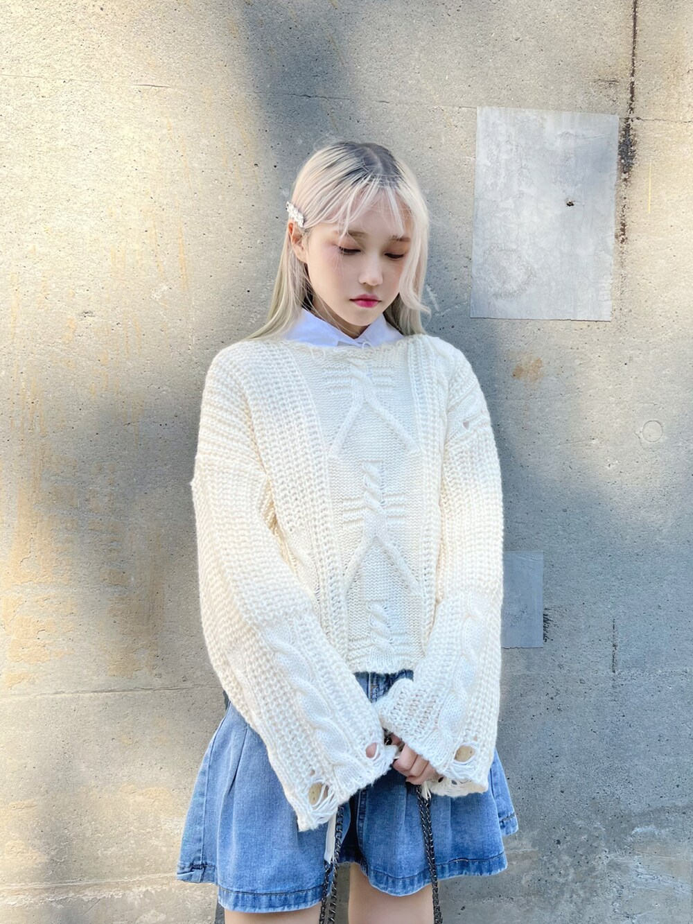 ホワイト系のシャツ/ブラウス、ホワイト系のニット/セーター、ブルー系のデニムスカートを着用したレディースの冬コーディネートの4枚目の写真