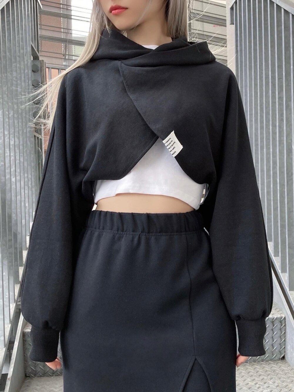 ブラック系のブーツ、ブラック系のスカート、ブラック系のパーカーを着用したレディースの春コーディネートの2枚目の写真