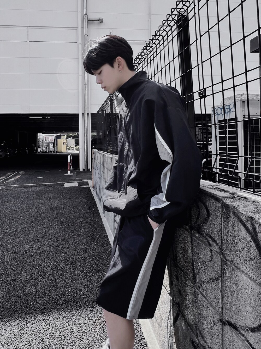 ブラック系のナイロンジャケット、グレー系のTシャツ/カットソー、ブラック系のその他パンツを着用したメンズの春コーディネートの2枚目の写真