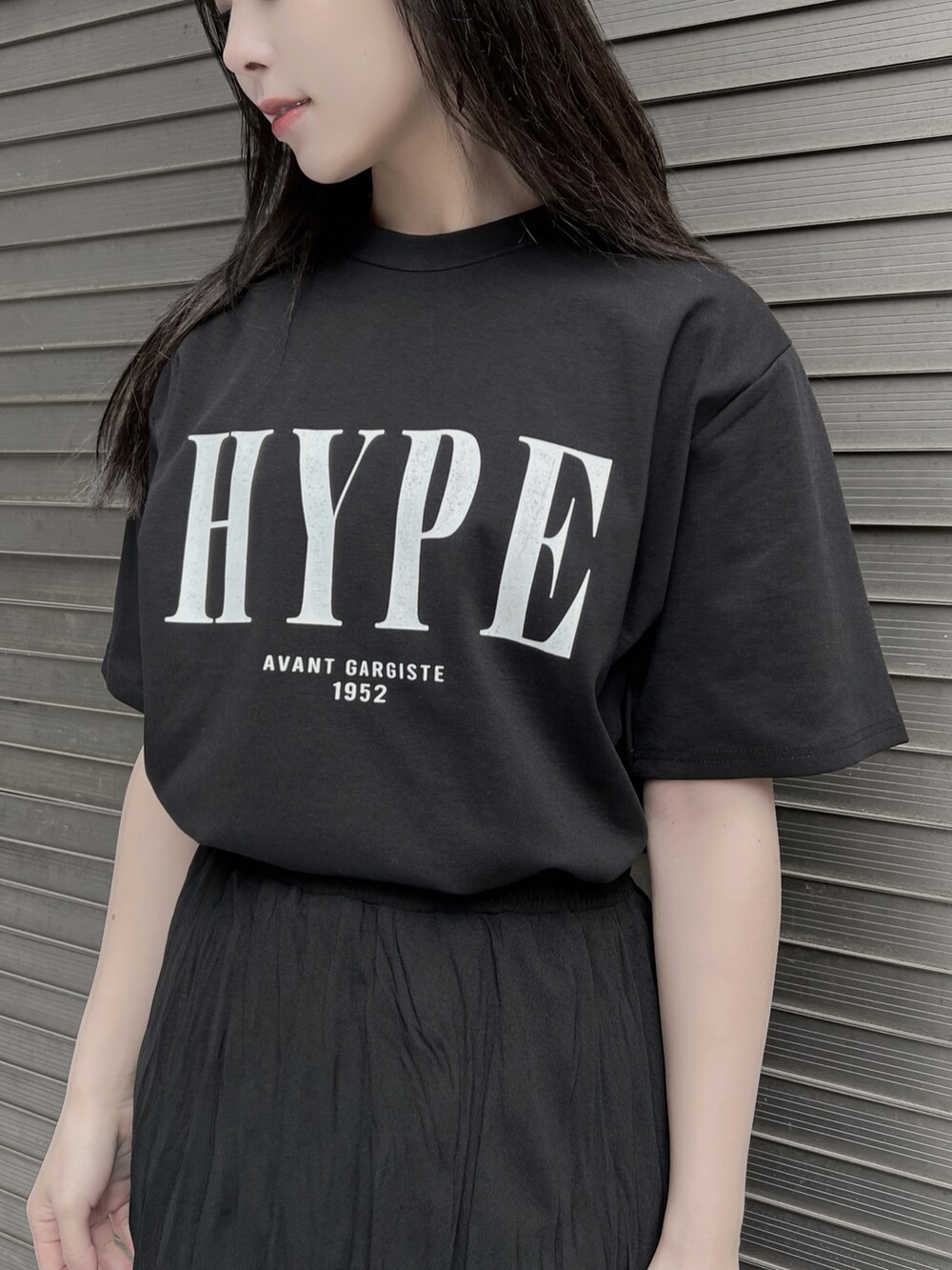 ブラック系のスカート、ブラック系のTシャツ/カットソー、ブラック系のサンダルを着用したレディースの夏コーディネートの2枚目の写真