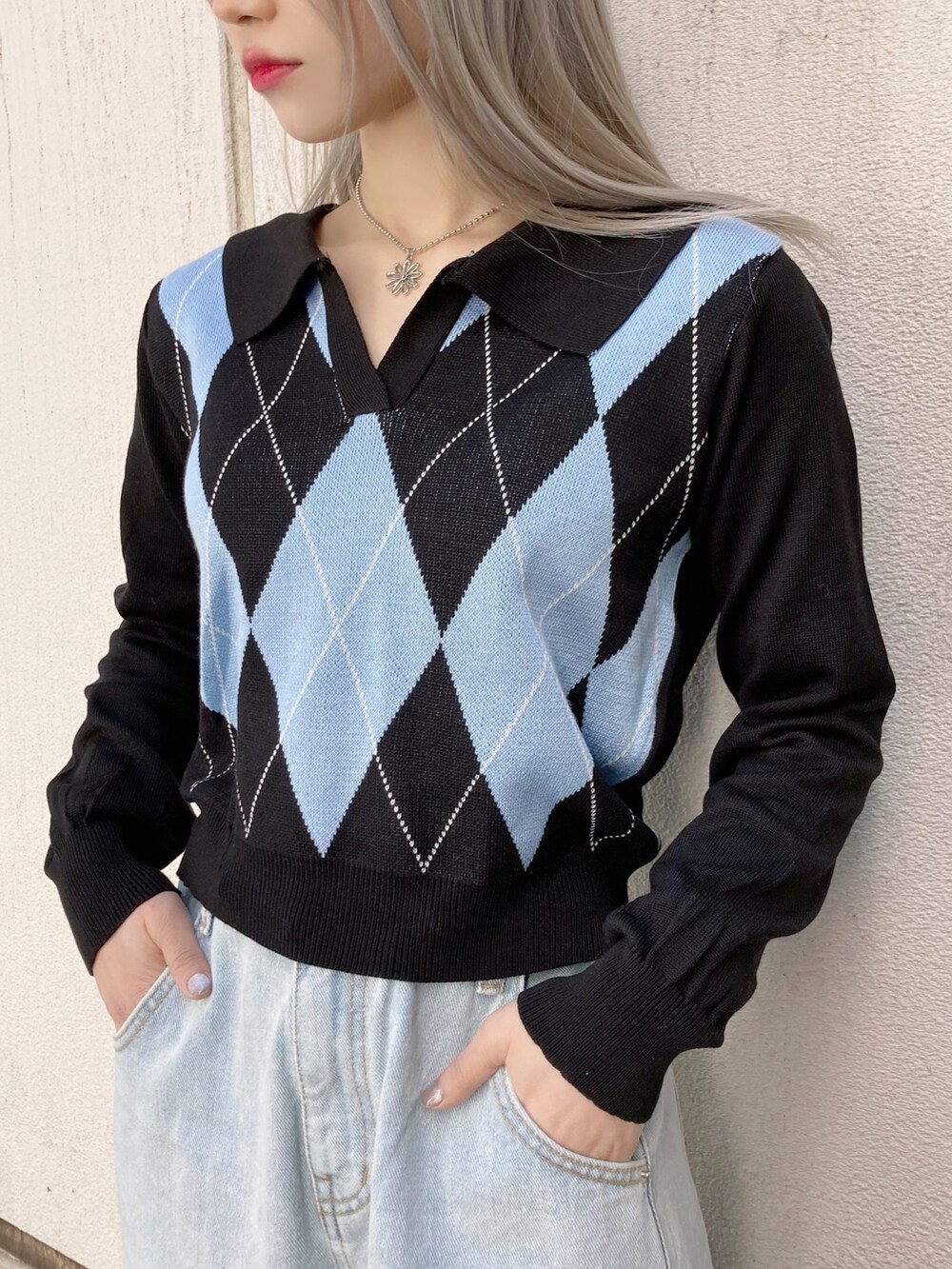 ホワイト系のスニーカー、ブルー系のデニムパンツ、ブルー系のニット/セーターを着用したレディースの春コーディネートの2枚目の写真