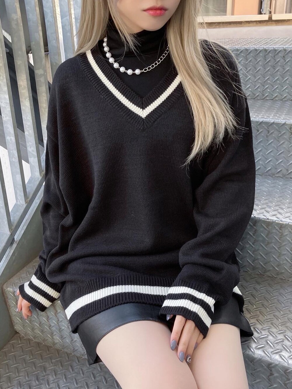 ブラック系のニット/セーター、ブラック系のトートバッグ、ブラック系のTシャツ/カットソーを着用したレディースの春コーディネートの2枚目の写真