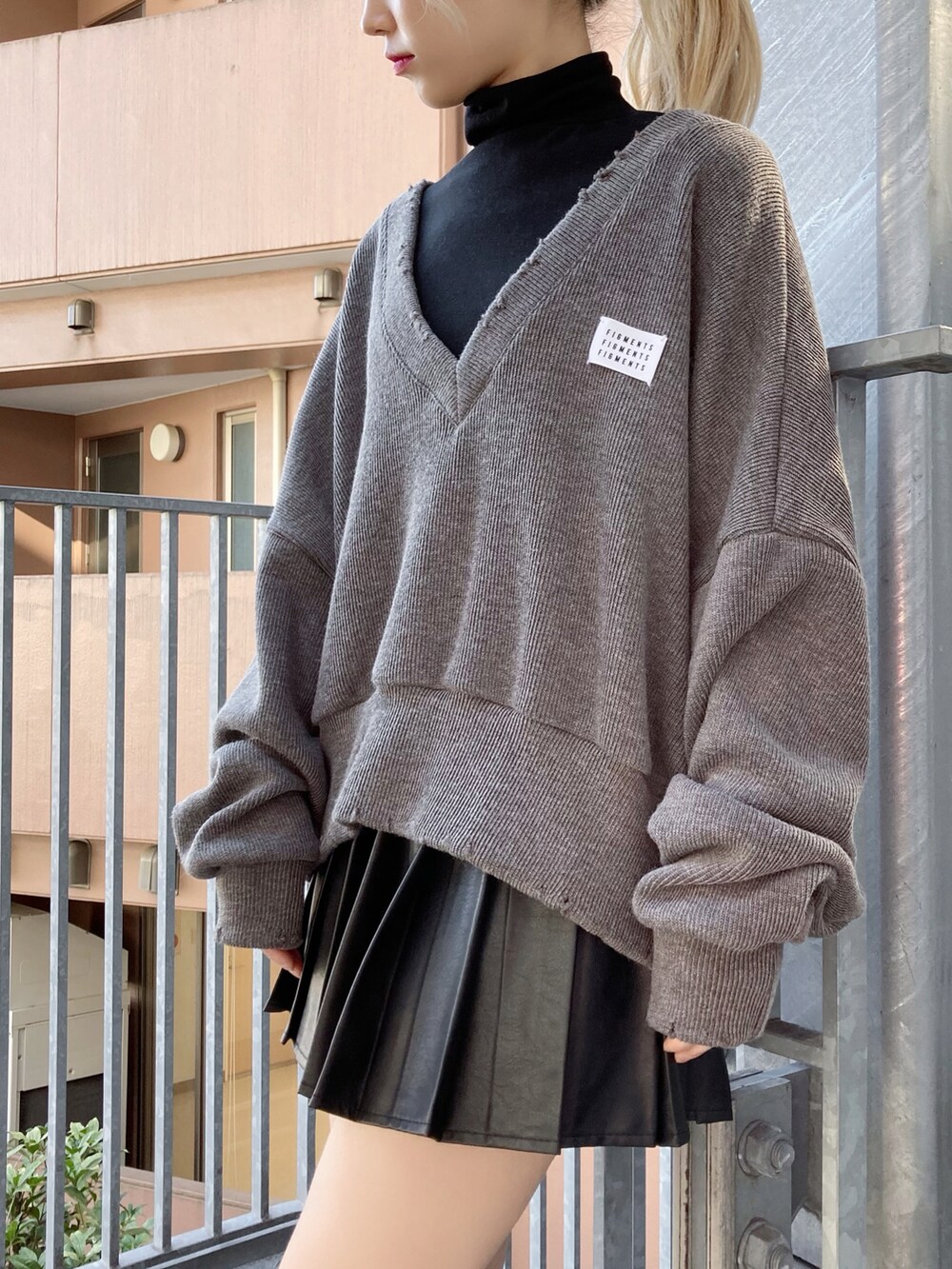 グレー系のニット/セーター、ブラック系のTシャツ/カットソー、ブラック系のスカートを着用したレディースの冬コーディネートの2枚目の写真