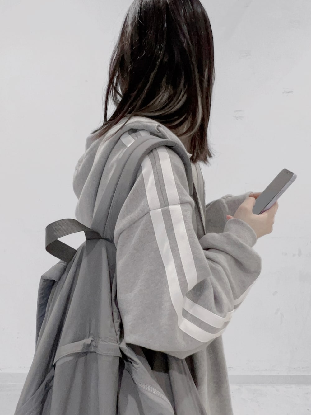 グレー系のバックパック/リュック、グレー系のパーカー、ブラック系のスカートを着用したレディースの秋コーディネートの3枚目の写真