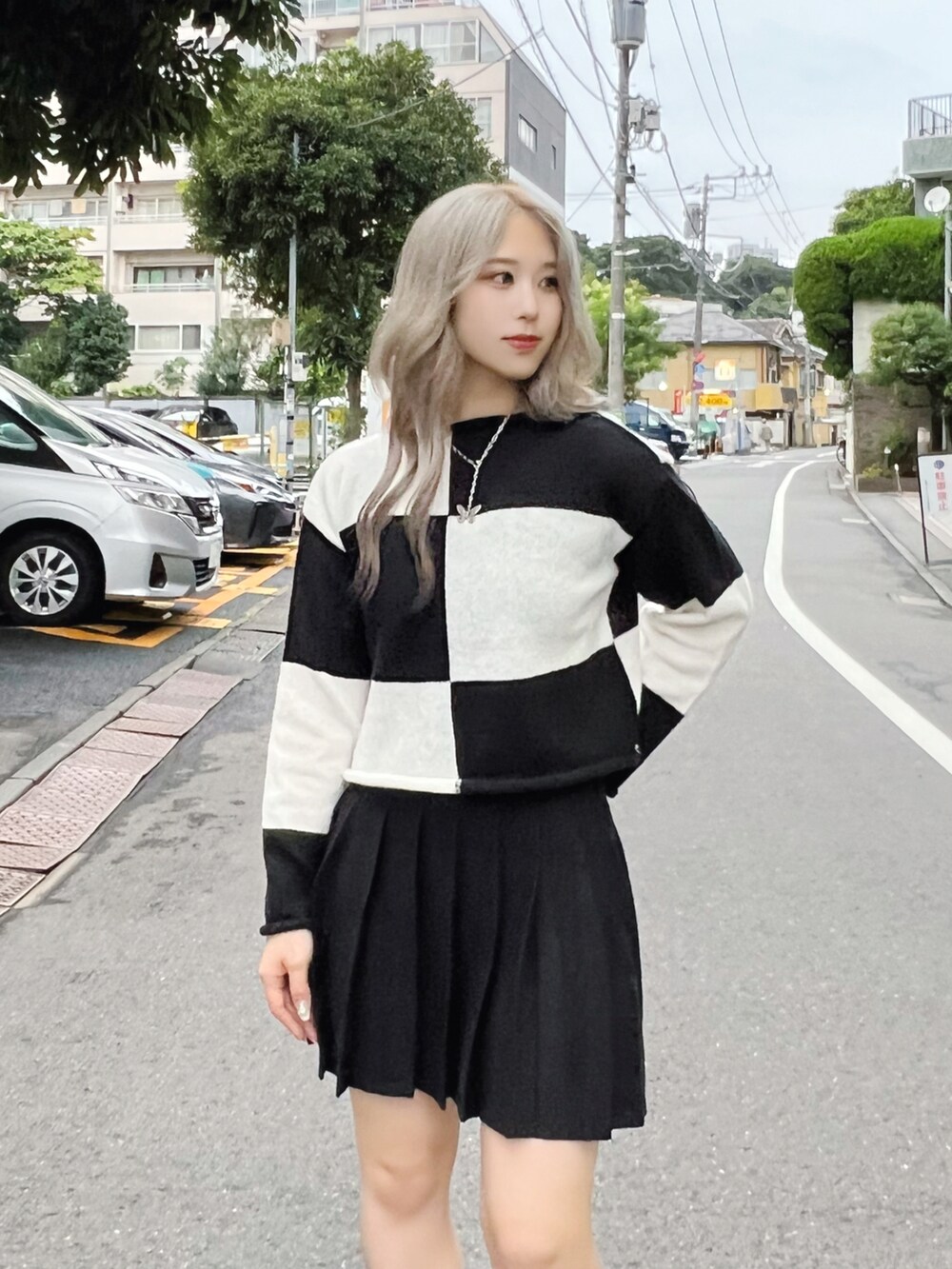 ブラック系のパーカー、ブラック系のニット/セーター、ブラック系のブーツを着用したレディースの秋コーディネートの3枚目の写真