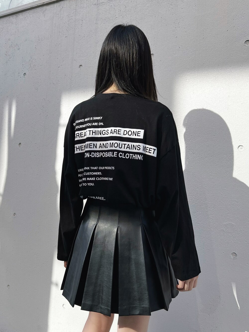 ブラック系のダウンジャケット/コート、ブラック系のTシャツ/カットソー、ブラック系のスカートを着用したレディースの冬コーディネートの3枚目の写真