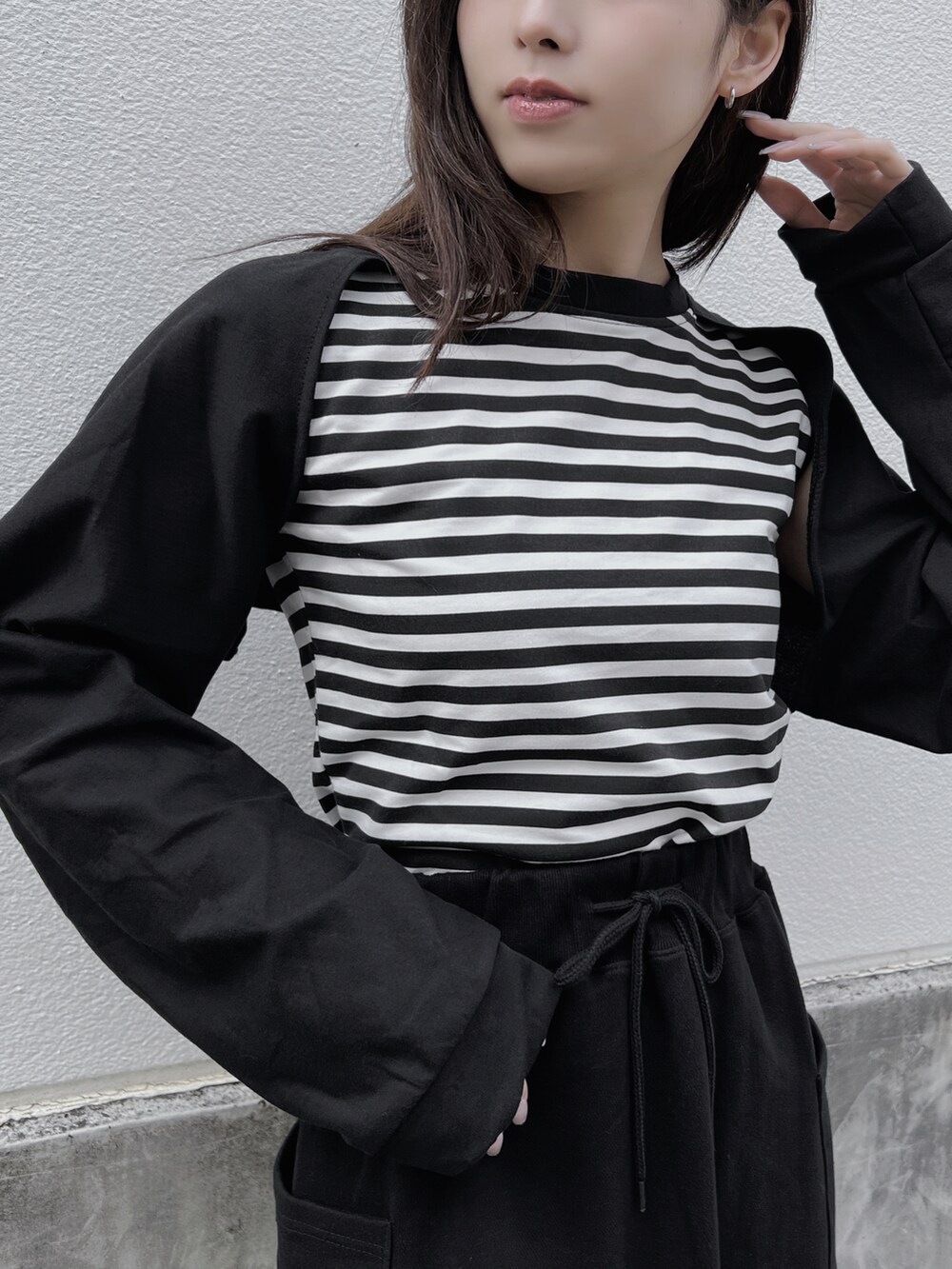 ブラック系のスカート、ブラック系のブーツ、ブラック系のカーディガン/ボレロを着用したレディースの春コーディネートの3枚目の写真