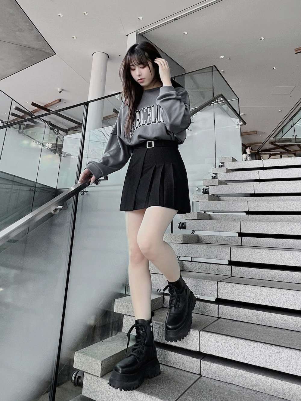 ブラック系のブーツ、ブラック系のスカート、グレー系のTシャツ/カットソーを着用したレディースの春コーディネートの2枚目の写真