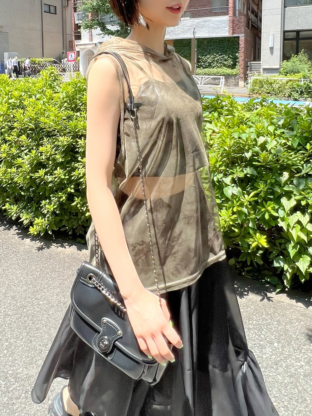 ブラック系のサンダル、ブラック系のスカート、グリーン系のTシャツ/カットソーを着用したレディースの夏コーディネートの2枚目の写真