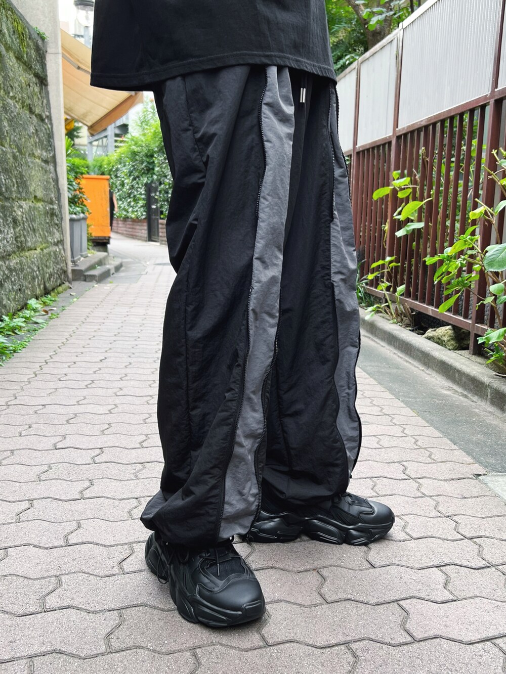 ブラック系のTシャツ/カットソー、ブラック系のその他パンツ、ブラック系のスニーカーを着用したメンズの秋コーディネートの3枚目の写真