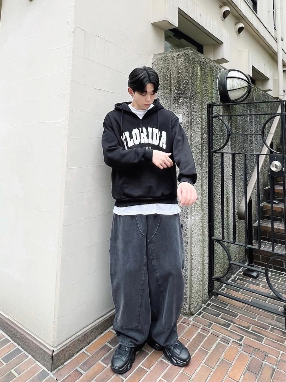 ブラック系のデニムパンツ、ブラック系のスニーカー、ブラック系のパーカーを着用したメンズの冬コーディネートの3枚目の写真