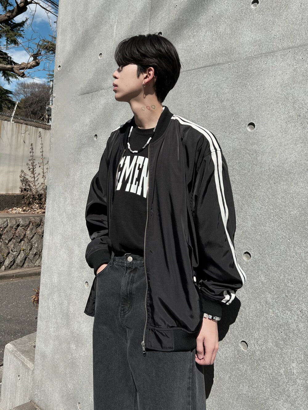 ブラック系のデニムパンツ、ブラック系のTシャツ/カットソー、ブラック系のブルゾンを着用したメンズの春コーディネートの2枚目の写真