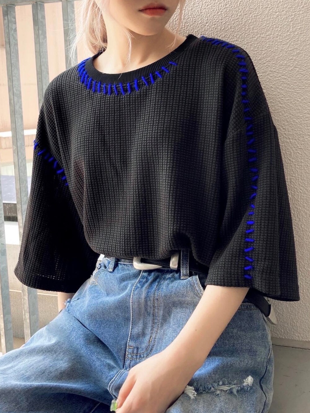 ブラック系のニット/セーター、ブルー系のデニムパンツ、ブラック系のスニーカーを着用したレディースの夏コーディネートの2枚目の写真