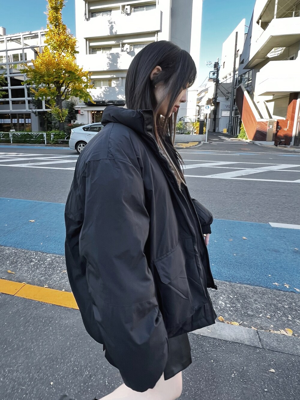 ブラック系のダウンジャケット/コート、ブラック系のTシャツ/カットソー、ブラック系のスカートを着用したレディースの冬コーディネートの5枚目の写真