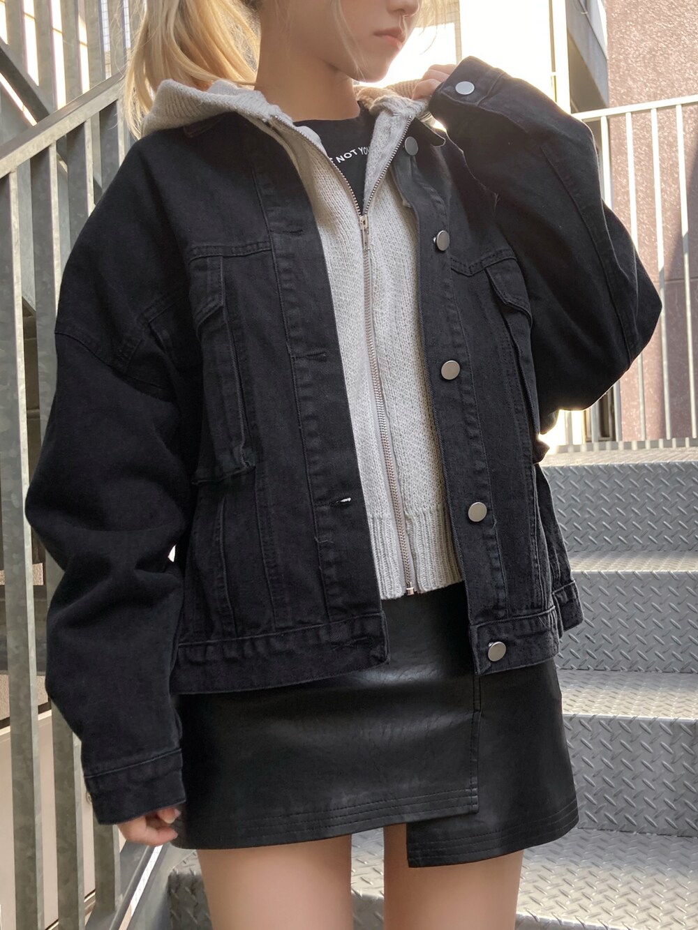 グレー系のカーディガン/ボレロ、ブラック系のデニムジャケット、ブラック系のスカートを着用したレディースの冬コーディネートの2枚目の写真