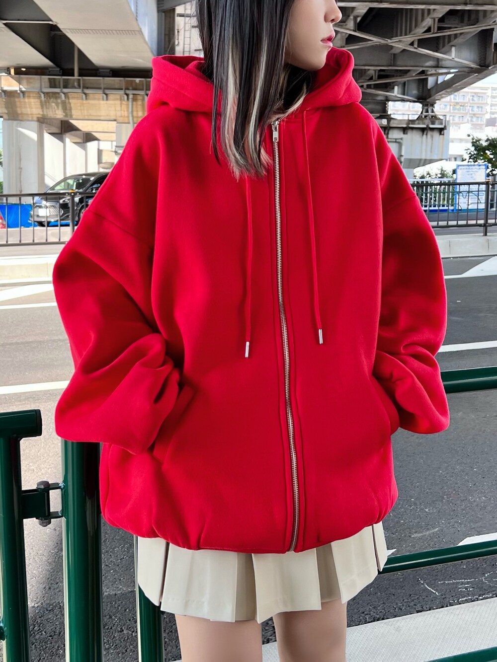 ホワイト系のスニーカー、ホワイト系のベスト、レッド系のパーカーを着用したレディースの冬コーディネートの4枚目の写真