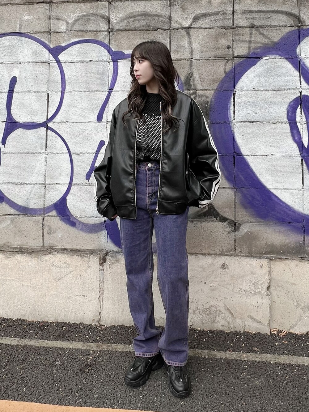 パープル系のデニムパンツ、ブラック系のTシャツ/カットソー、ブラック系のブルゾンを着用したレディースの冬コーディネートの2枚目の写真