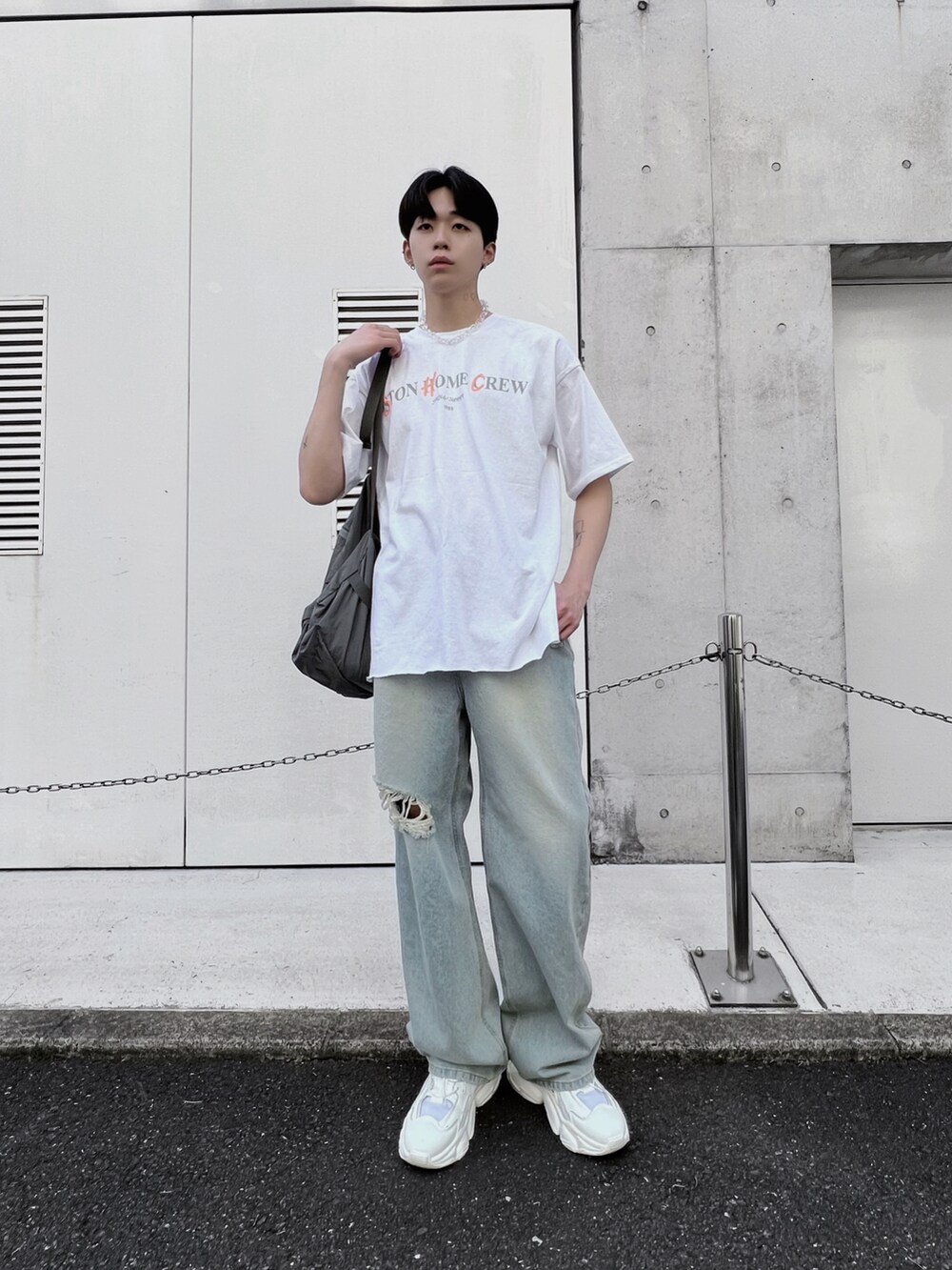 ブルー系のデニムパンツ、グレー系のバックパック/リュック、ホワイト系のTシャツ/カットソーを着用したメンズの春コーディネートの3枚目の写真