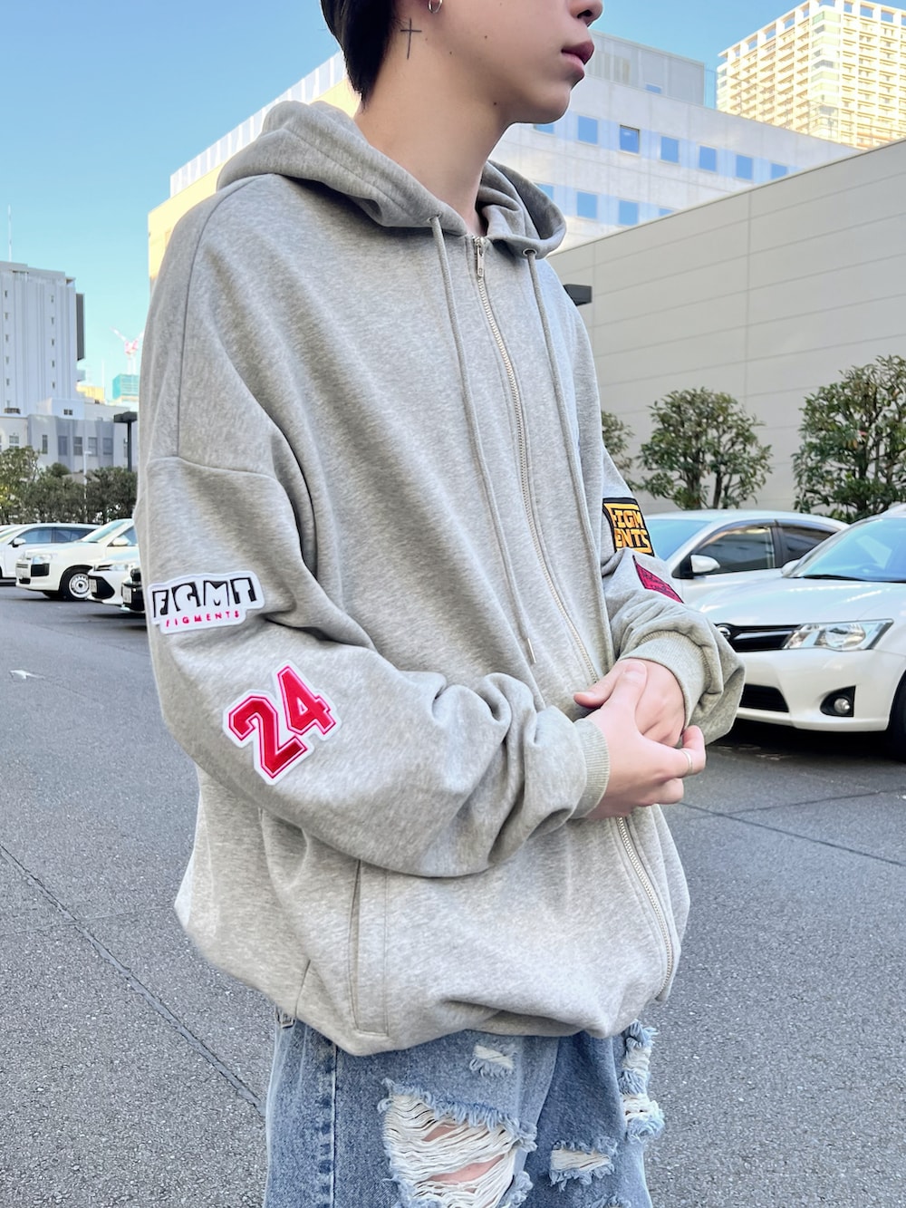 グレー系のパーカー、ブルー系のデニムパンツを着用したメンズの冬コーディネートの3枚目の写真