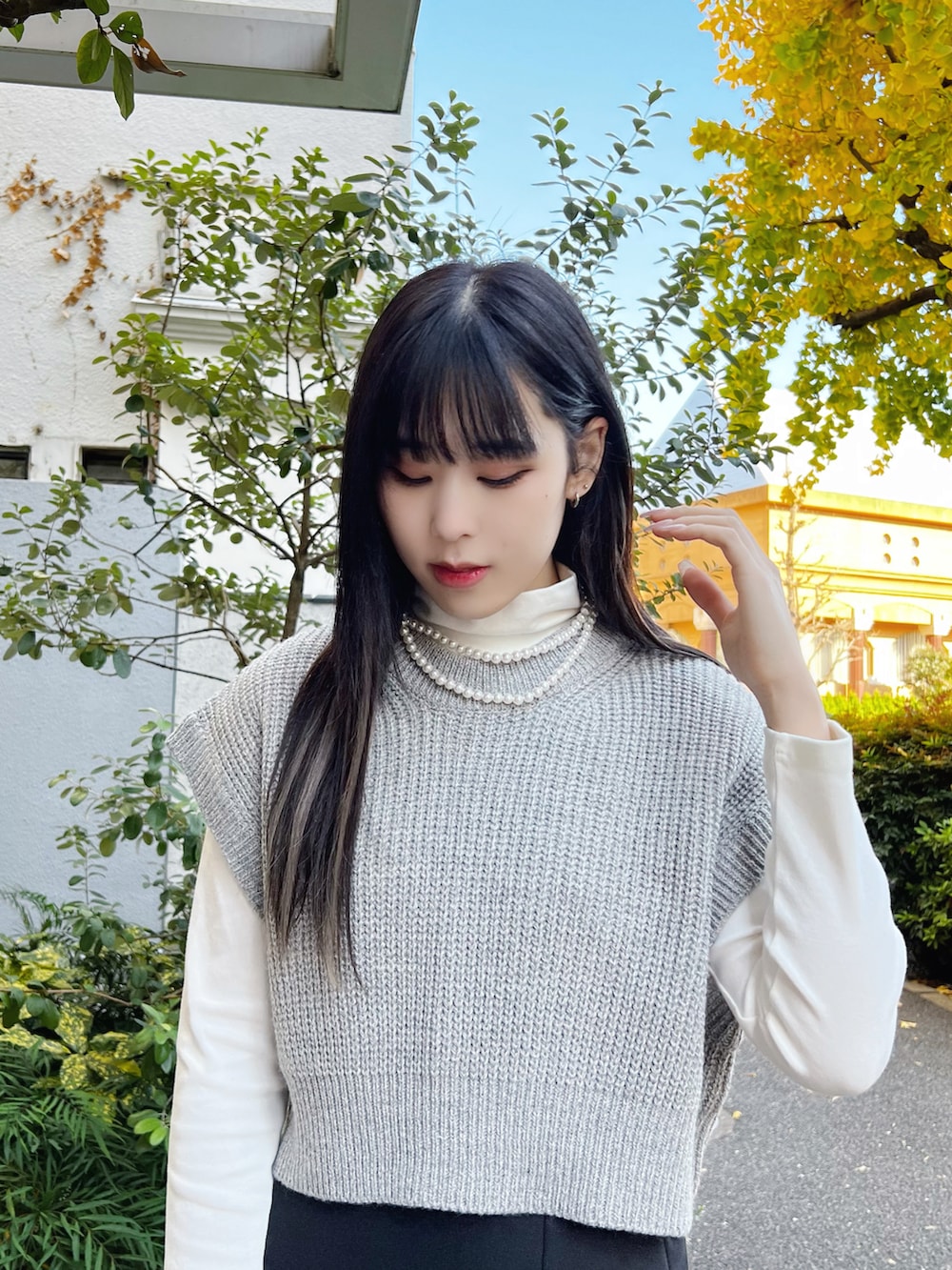 ブラック系のスカート、グレー系のベスト、ホワイト系のTシャツ/カットソーを着用したレディースの冬コーディネートの3枚目の写真