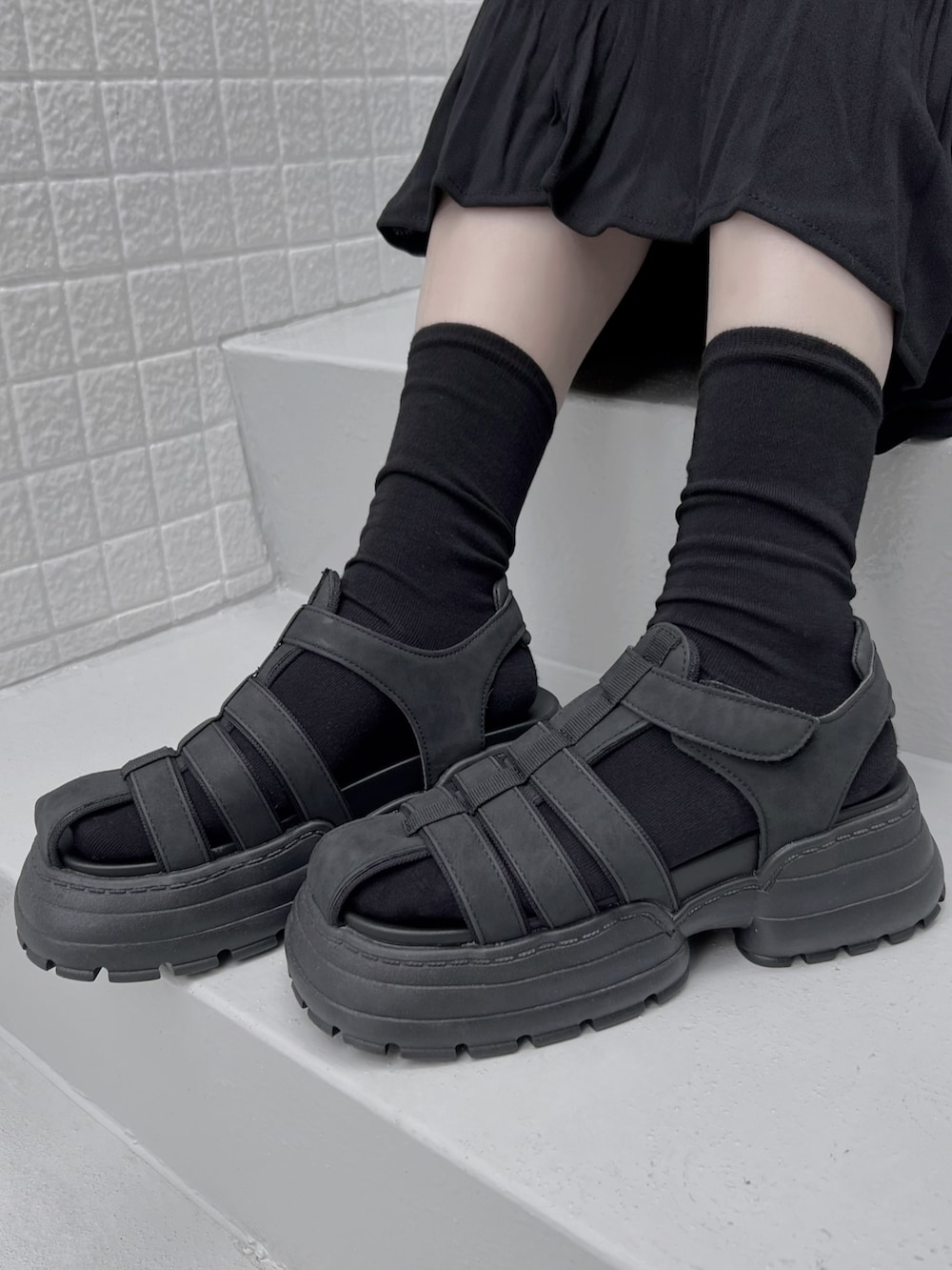 ブラック系のスカート、ブラック系のTシャツ/カットソー、ブラック系のサンダルを着用したレディースの夏コーディネートの4枚目の写真