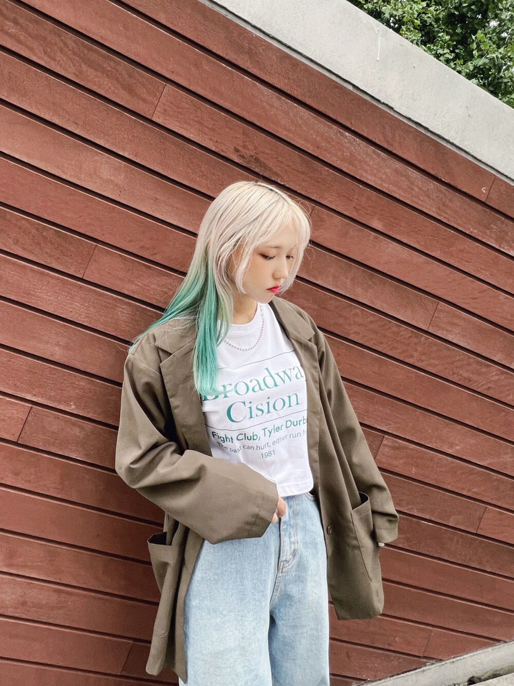 グリーン系のテーラードジャケット、ホワイト系のTシャツ/カットソー、ブルー系のデニムパンツを着用したレディースの秋コーディネートの2枚目の写真