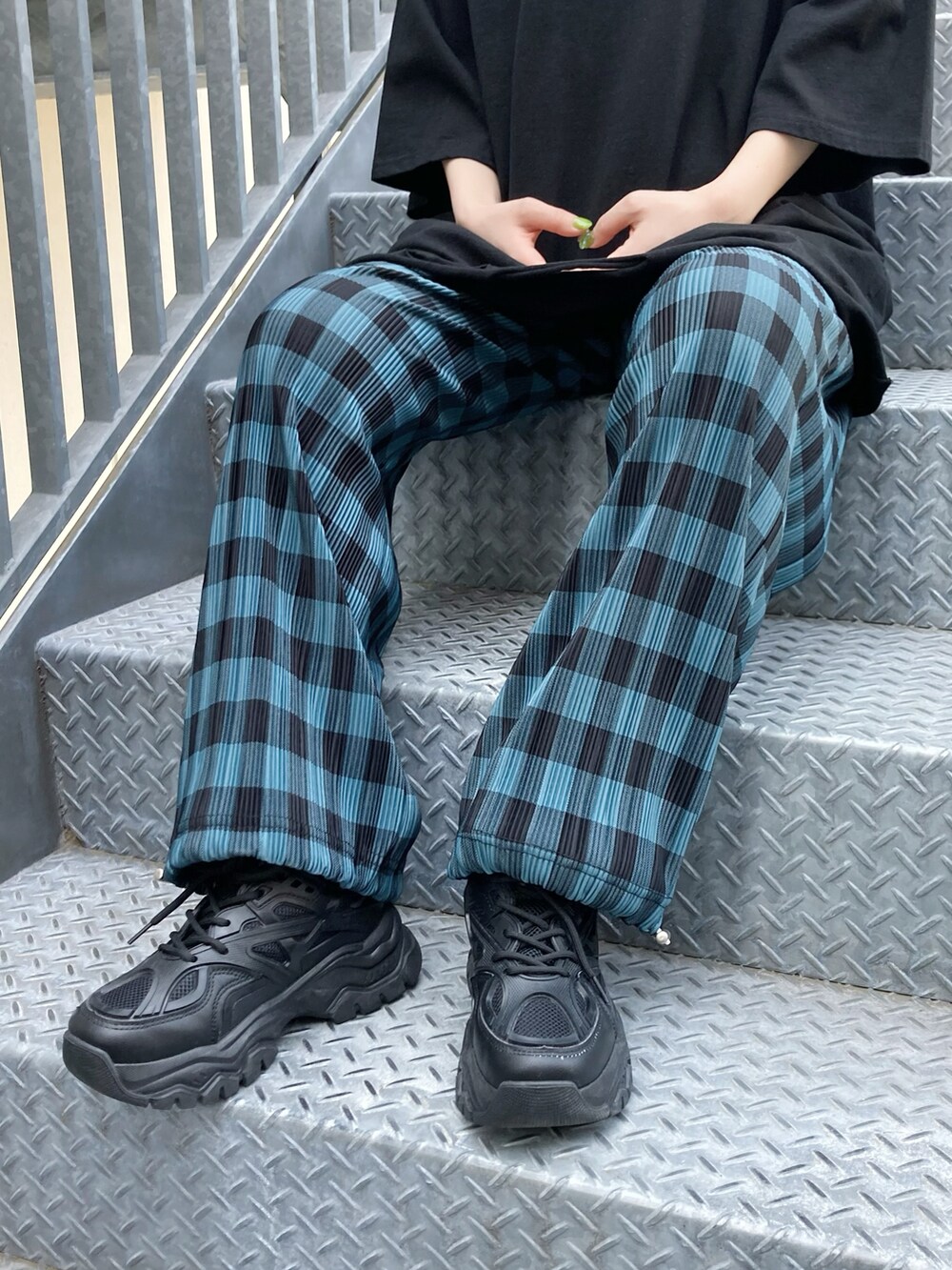 ブラック系のTシャツ/カットソー、ブルー系のその他パンツ、ブラック系のスニーカーを着用したレディースの春コーディネートの2枚目の写真