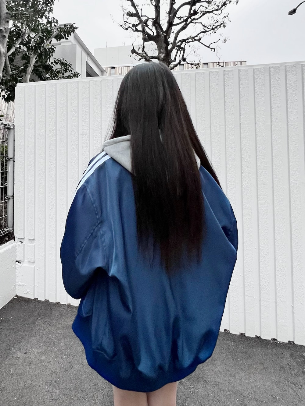 グレー系のパーカー、ブルー系のブルゾンを着用したレディースの冬コーディネートの4枚目の写真