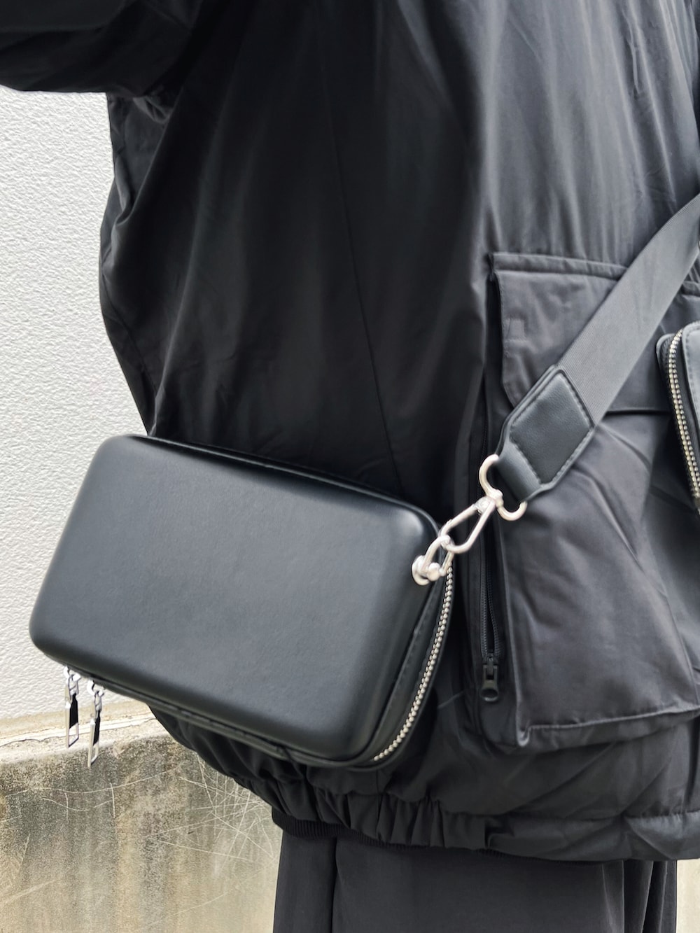 ブラック系のスニーカー、ブラック系のカーゴパンツ、ブラック系のダウンジャケット/コートを着用したメンズの冬コーディネートの4枚目の写真