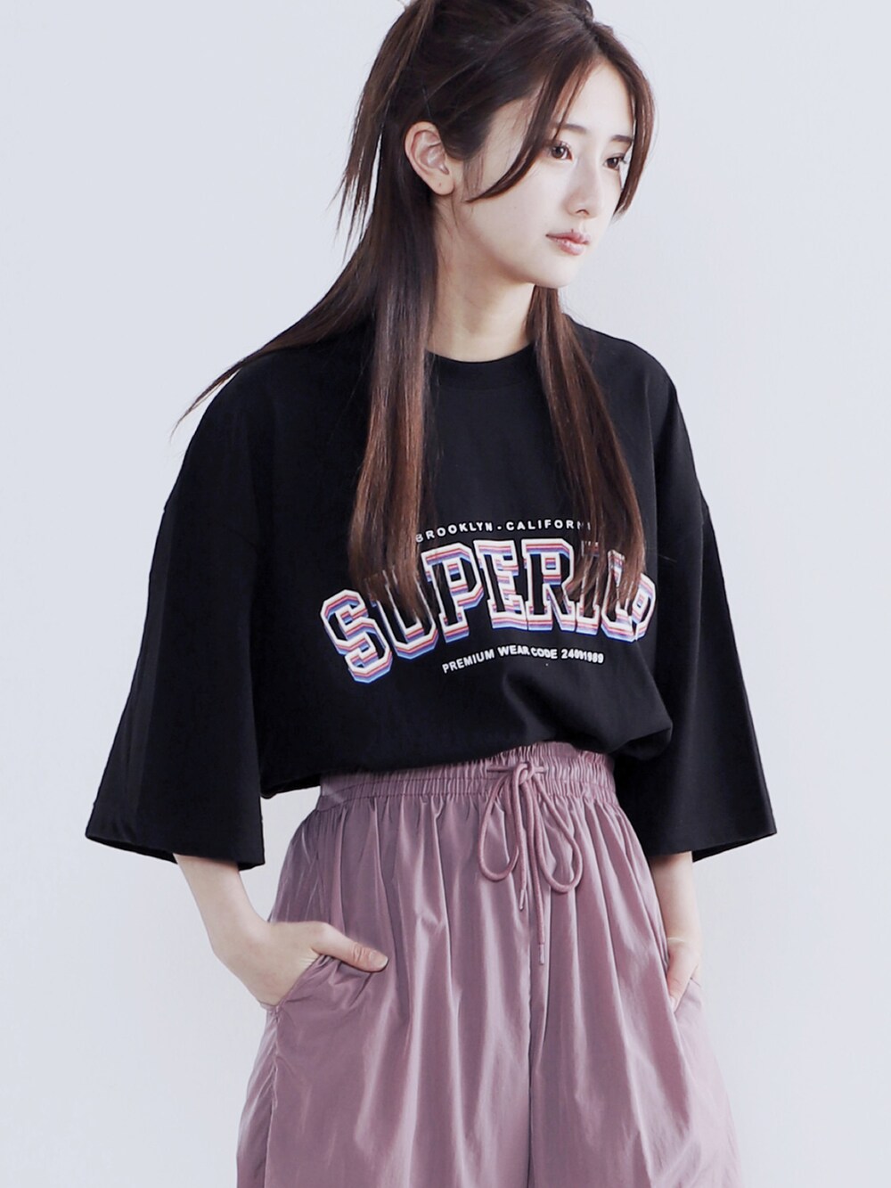 ピンク系のその他パンツ、ブラック系のスニーカー、ブラック系のTシャツ/カットソーを着用したレディースの夏コーディネートの3枚目の写真